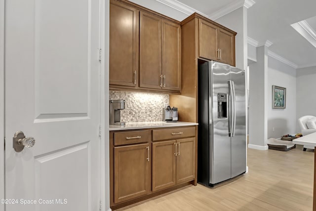 kitchen with backsplash, crown molding, light hardwood / wood-style floors, and stainless steel refrigerator with ice dispenser