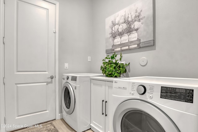 laundry area featuring light wood-type flooring and washing machine and clothes dryer