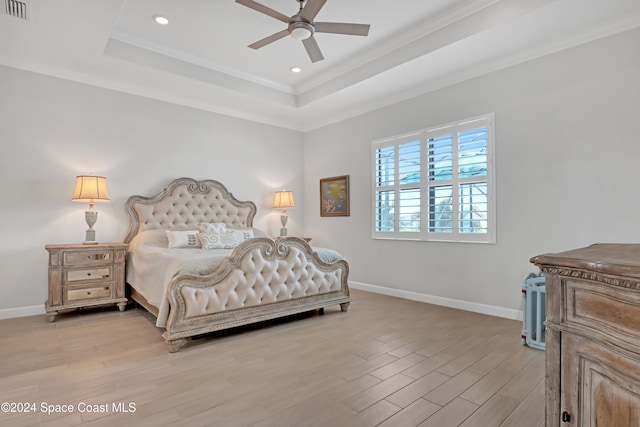 bedroom featuring a tray ceiling, light hardwood / wood-style flooring, and ceiling fan