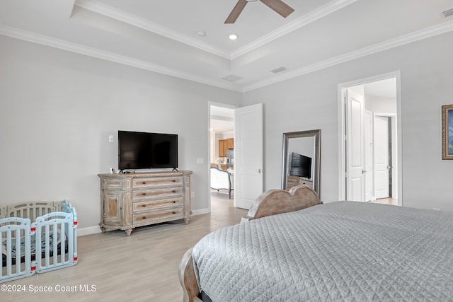 bedroom featuring a raised ceiling, ceiling fan, light hardwood / wood-style floors, and ornamental molding