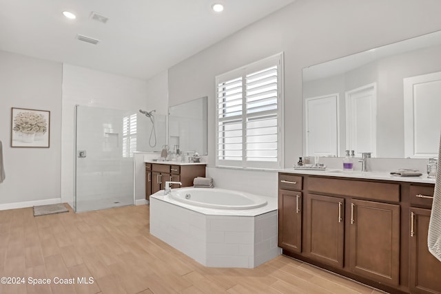 bathroom featuring hardwood / wood-style floors, vanity, and independent shower and bath