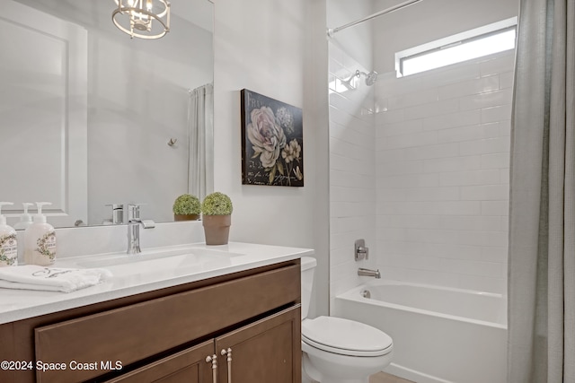 full bathroom with an inviting chandelier, vanity, shower / tub combo, and toilet