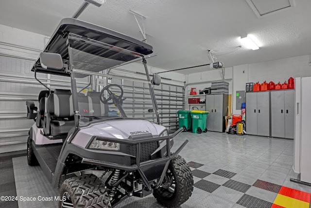 garage with white refrigerator and a garage door opener