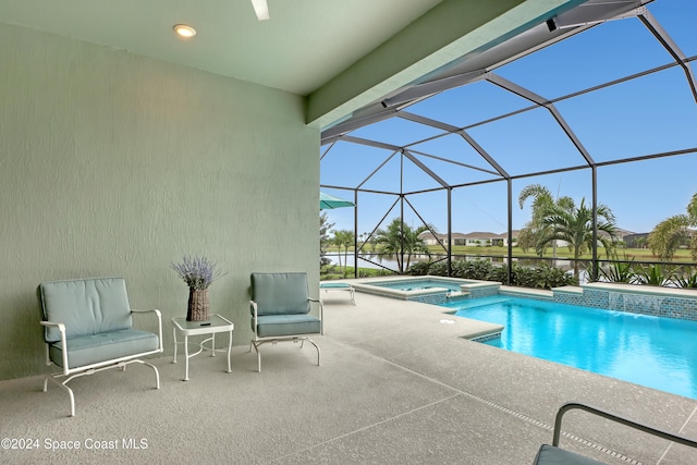 view of swimming pool featuring an in ground hot tub, pool water feature, glass enclosure, and a patio area