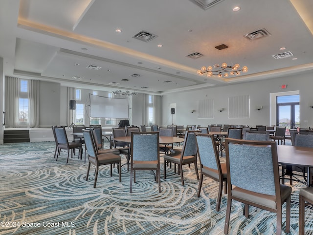 dining area featuring carpet floors and a tray ceiling