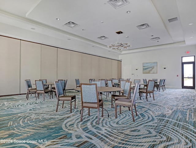 dining room with carpet and a tray ceiling