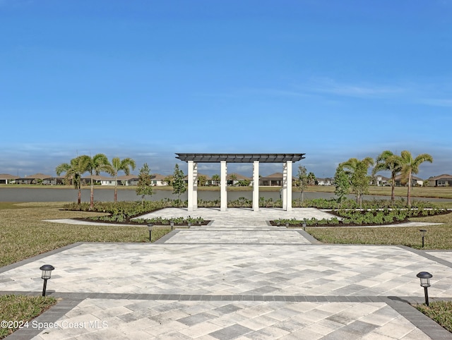 surrounding community with a pergola and a water view