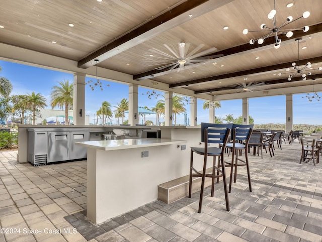 view of patio featuring ceiling fan and exterior bar