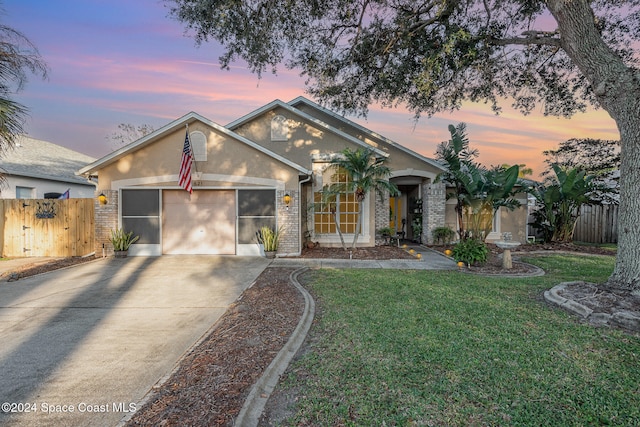 ranch-style home featuring a yard and a garage