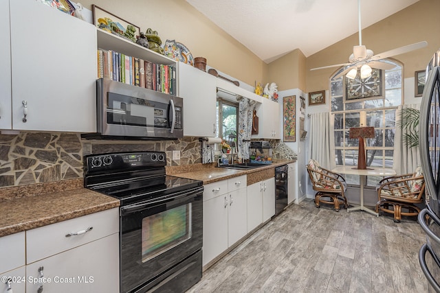 kitchen with ceiling fan, vaulted ceiling, white cabinets, black appliances, and light wood-type flooring