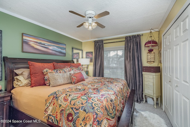 carpeted bedroom featuring a closet, ornamental molding, and ceiling fan