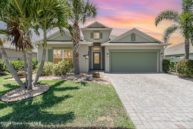 view of front of property with a garage and a lawn