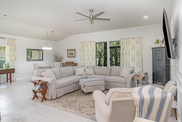 tiled living room with ceiling fan with notable chandelier and lofted ceiling