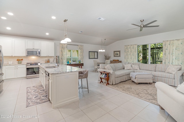 kitchen featuring white cabinetry, a kitchen island with sink, sink, and appliances with stainless steel finishes