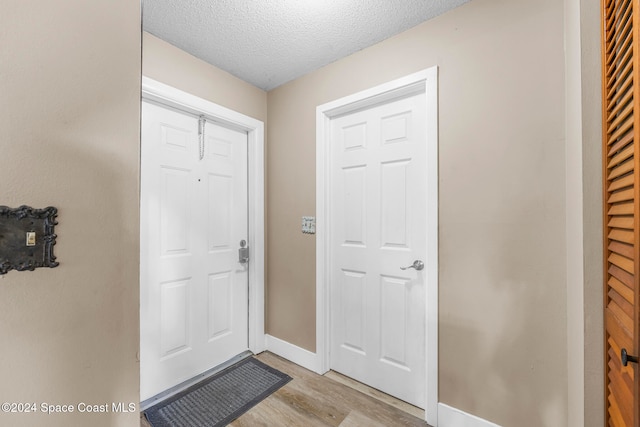 foyer entrance featuring light wood-type flooring and a textured ceiling