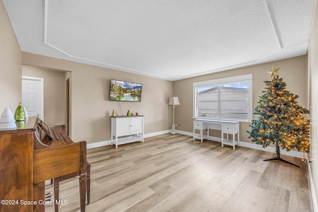 miscellaneous room with light hardwood / wood-style floors and a textured ceiling