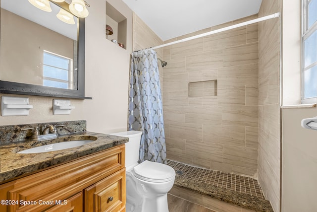 bathroom featuring curtained shower, hardwood / wood-style floors, vanity, and toilet