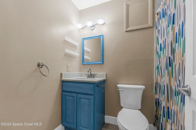 bathroom featuring walk in shower, vanity, and toilet