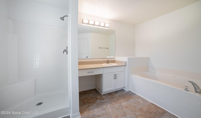 bathroom featuring vanity, independent shower and bath, and a textured ceiling