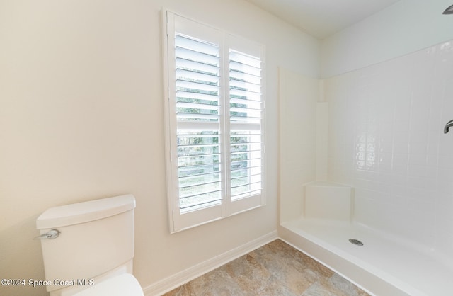 bathroom with walk in shower, a healthy amount of sunlight, and toilet