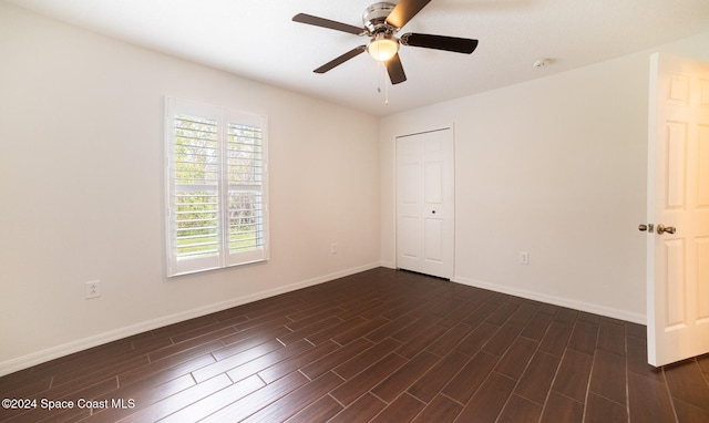 spare room featuring ceiling fan and dark wood-type flooring