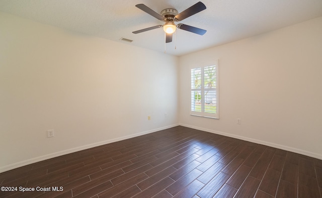 spare room featuring a textured ceiling, ceiling fan, and dark wood-type flooring