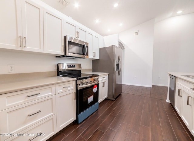 kitchen featuring white cabinets, appliances with stainless steel finishes, and dark hardwood / wood-style floors