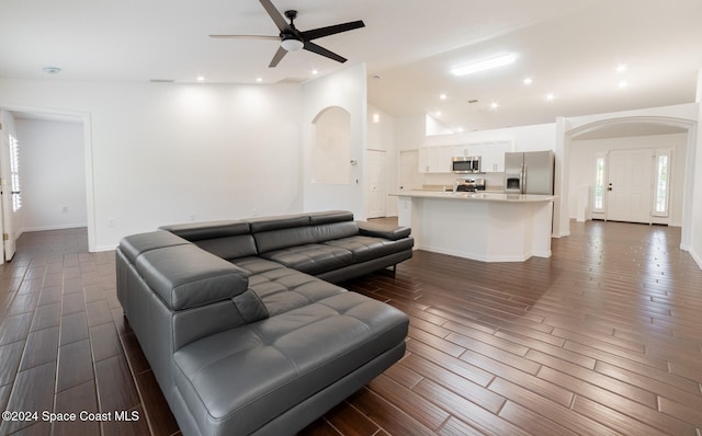 living room with dark hardwood / wood-style flooring, high vaulted ceiling, and ceiling fan