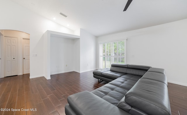 living room with ceiling fan, high vaulted ceiling, and dark wood-type flooring