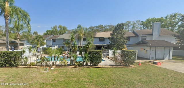 exterior space with a fenced in pool and a front lawn