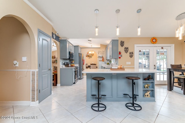 kitchen with light tile patterned flooring, appliances with stainless steel finishes, hanging light fixtures, and sink