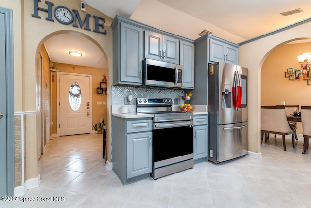 kitchen with appliances with stainless steel finishes, backsplash, and light tile patterned floors