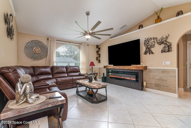 tiled living room with vaulted ceiling, ceiling fan, and tile walls