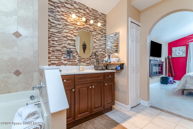 bathroom with tile patterned floors, vanity, and a bath