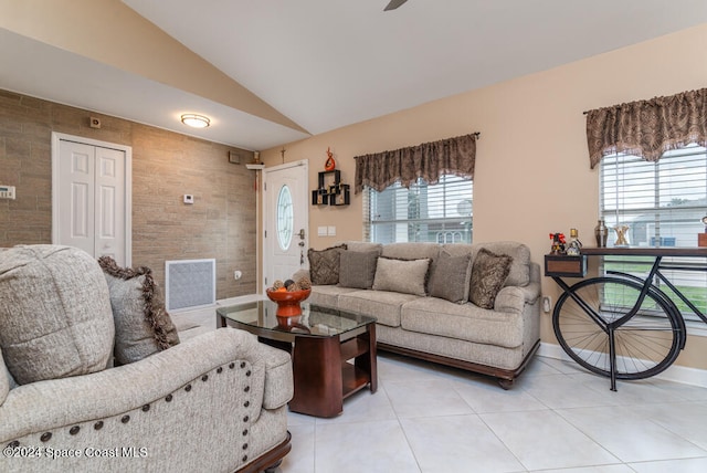 tiled living room with plenty of natural light and lofted ceiling