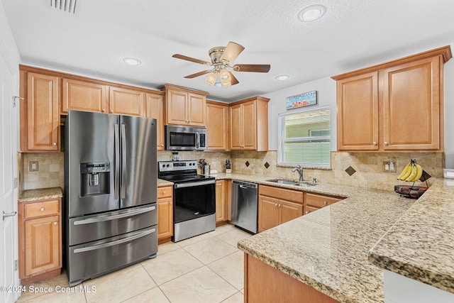 kitchen featuring appliances with stainless steel finishes, a textured ceiling, ceiling fan, and sink