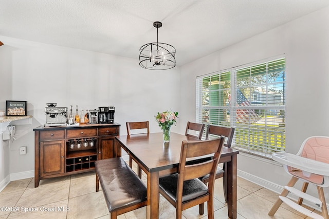 dining space with light tile patterned floors, a textured ceiling, a wealth of natural light, and a notable chandelier