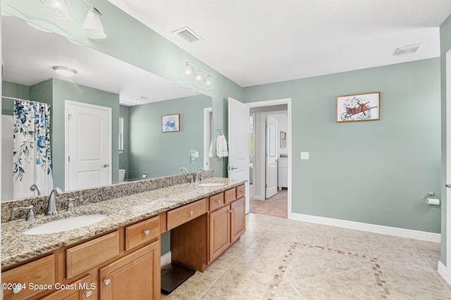 bathroom with tile patterned floors, vanity, toilet, and a textured ceiling