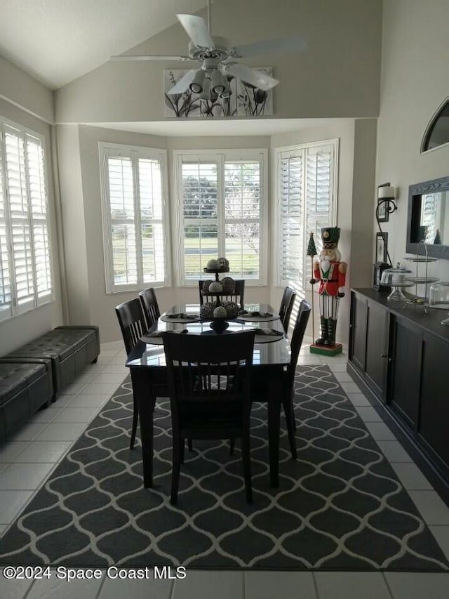 dining space featuring light tile patterned floors, high vaulted ceiling, and ceiling fan