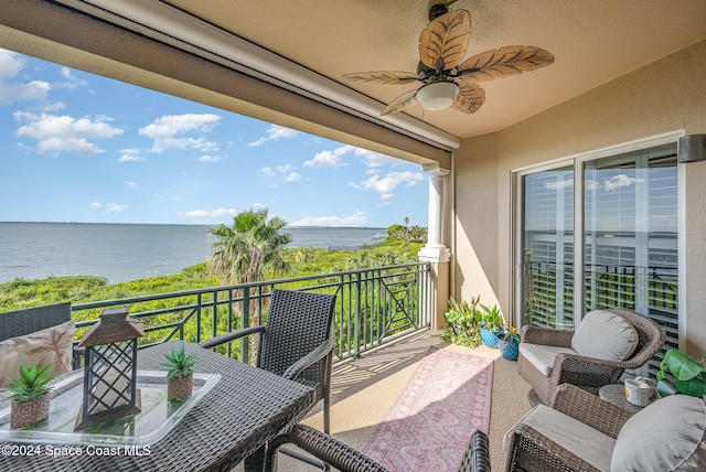 balcony with ceiling fan and a water view