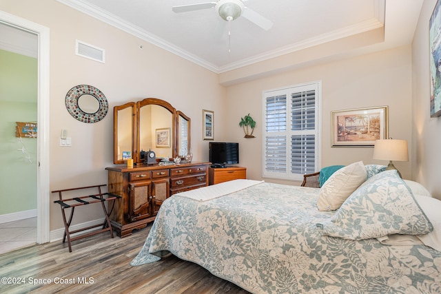 bedroom with ceiling fan, hardwood / wood-style floors, and ornamental molding