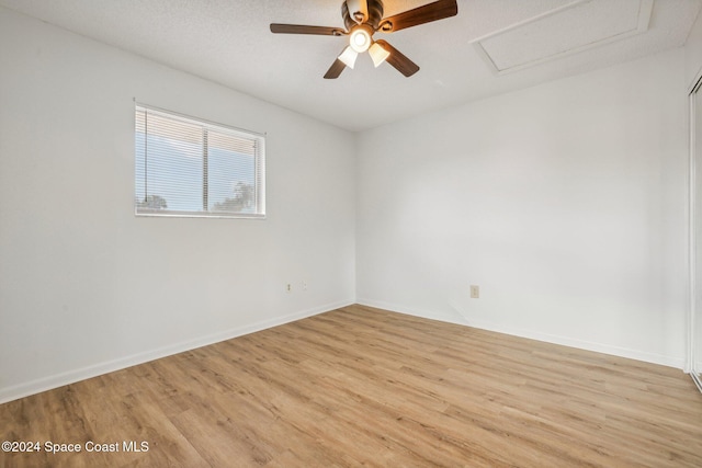 unfurnished room featuring a textured ceiling, light hardwood / wood-style floors, and ceiling fan