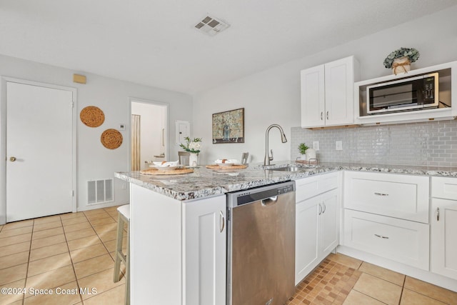 kitchen with sink, decorative backsplash, light stone countertops, white cabinetry, and stainless steel appliances