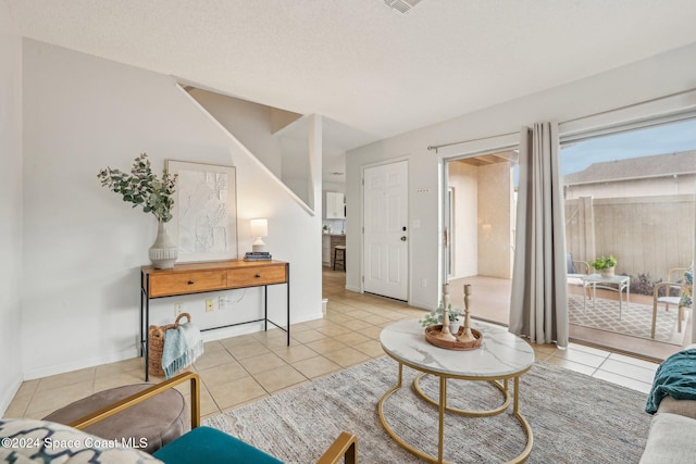 tiled living room featuring a textured ceiling