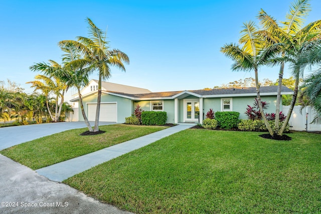 single story home featuring french doors, a front yard, and a garage