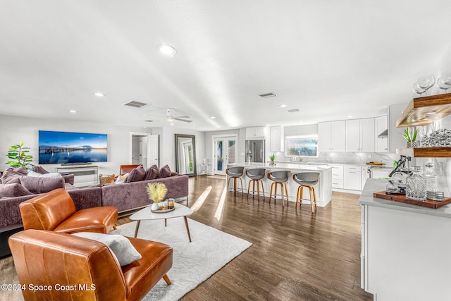 living room with ceiling fan and dark hardwood / wood-style flooring