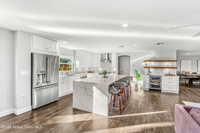 kitchen with white cabinets, sink, wall chimney exhaust hood, and appliances with stainless steel finishes