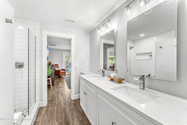 bathroom featuring a tile shower, vanity, and hardwood / wood-style flooring