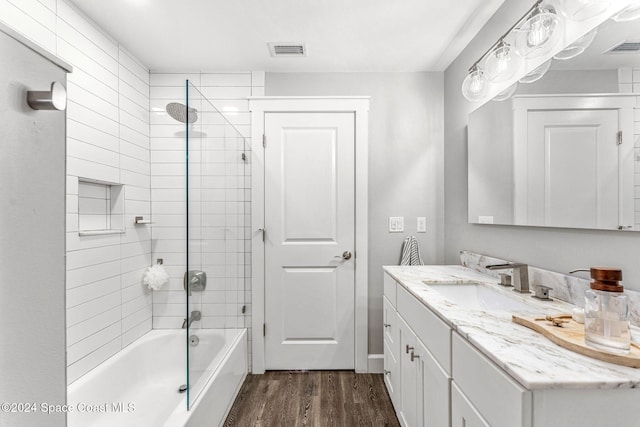 bathroom featuring vanity, wood-type flooring, and tiled shower / bath combo