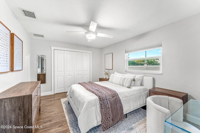 bedroom with ceiling fan, light hardwood / wood-style floors, and a closet